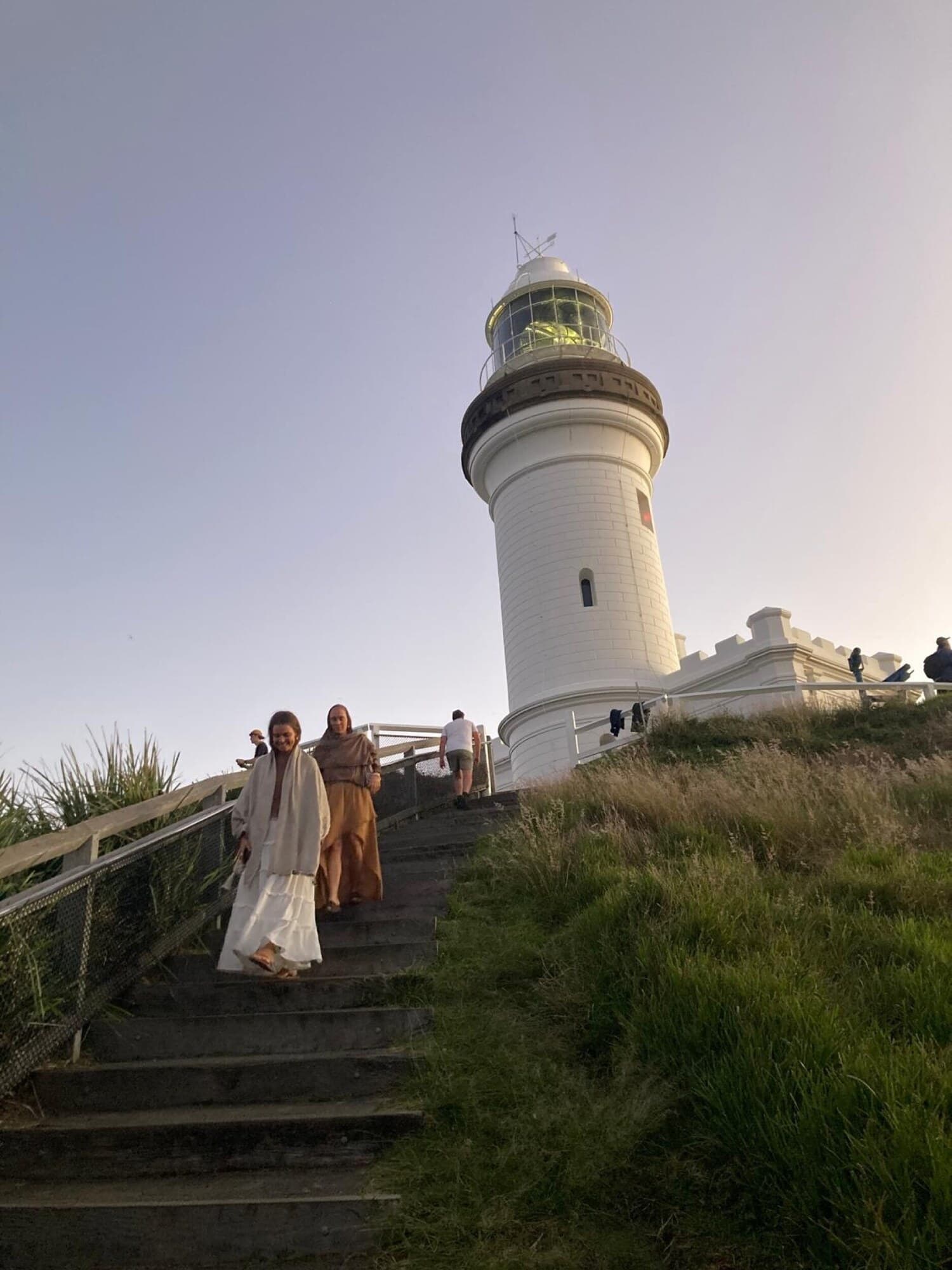 Tribe members walking up the steps to the lighthouse at dusk in Australia.